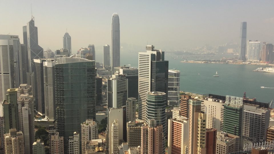 Výhled na ikonické mrakodrapy čtvrti Central a protilehlého Kowloonu z otáčející se restaurace na vrcholu věžáku Hopewell Centre